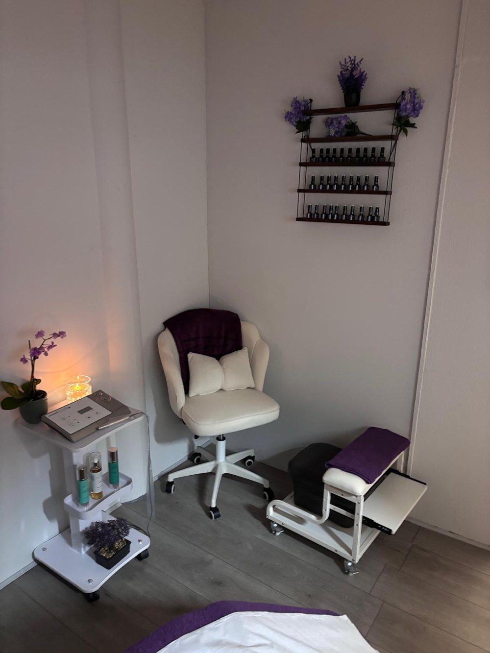 The nail station, with gel colours on the wall and a pedicure stool